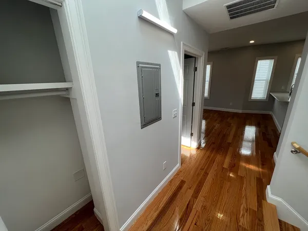 a view of a hallway with wooden floor and stairs