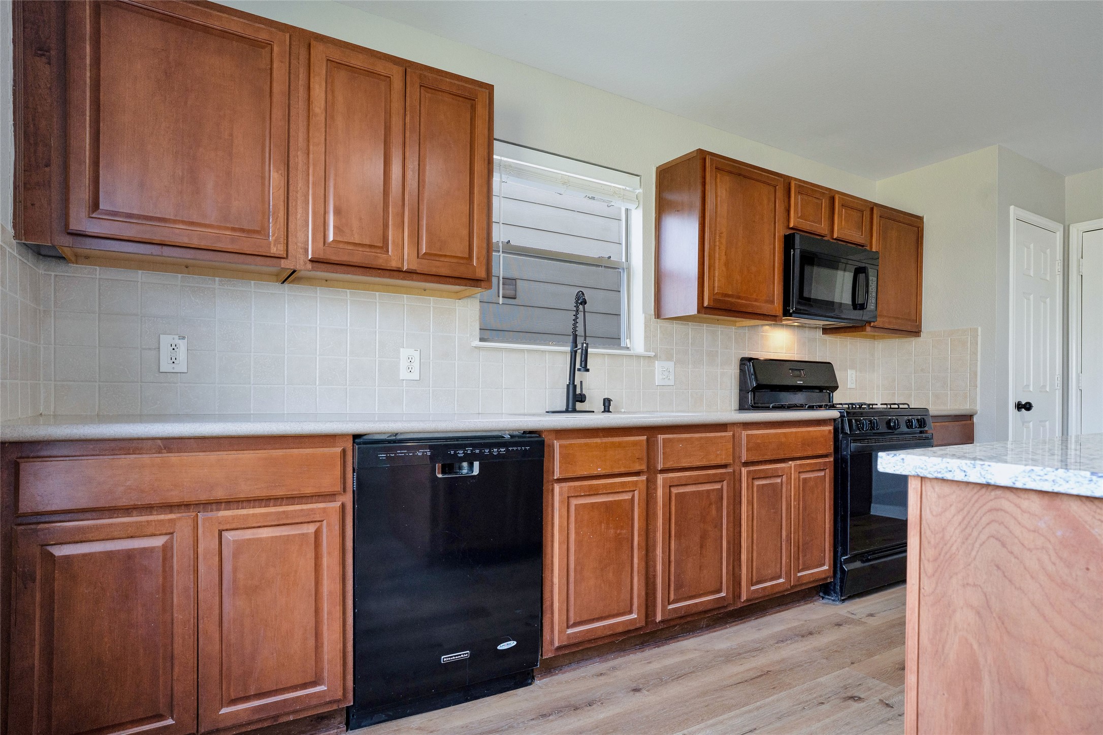3630 Avalon Castle Drive Spring, TX 77386 - Photo 17 of 39 a kitchen with stainless steel appliances granite countertop a stove a sink dishwasher and a microwave oven with wooden cabinets