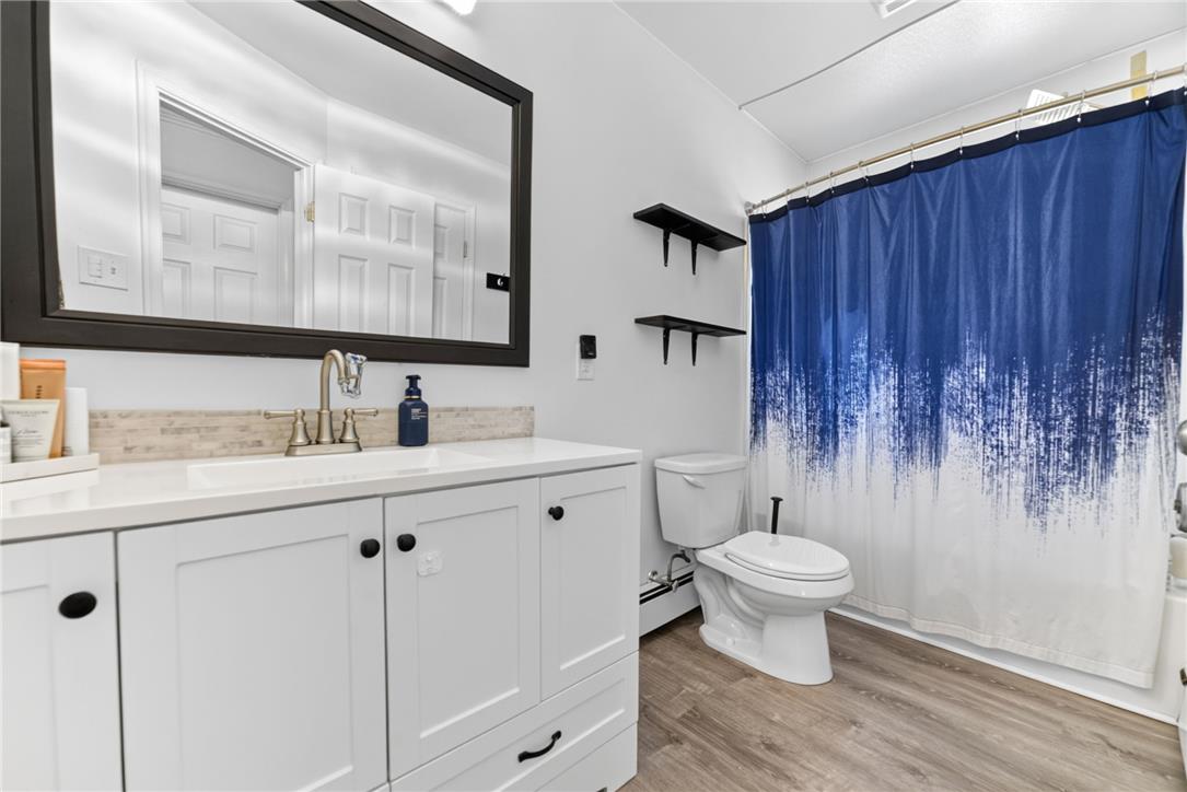 7290 Heather Road Macungie, PA 18062 - Photo 23 of 39 A well-appointed bathroom offers a clean aesthetic with a modern vanity and warm wood-look flooring.
