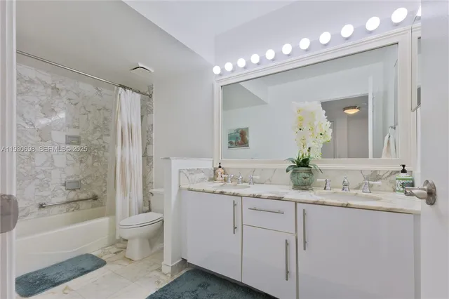 a bathroom with a granite countertop sink a toilet a bathtub a mirror and shower