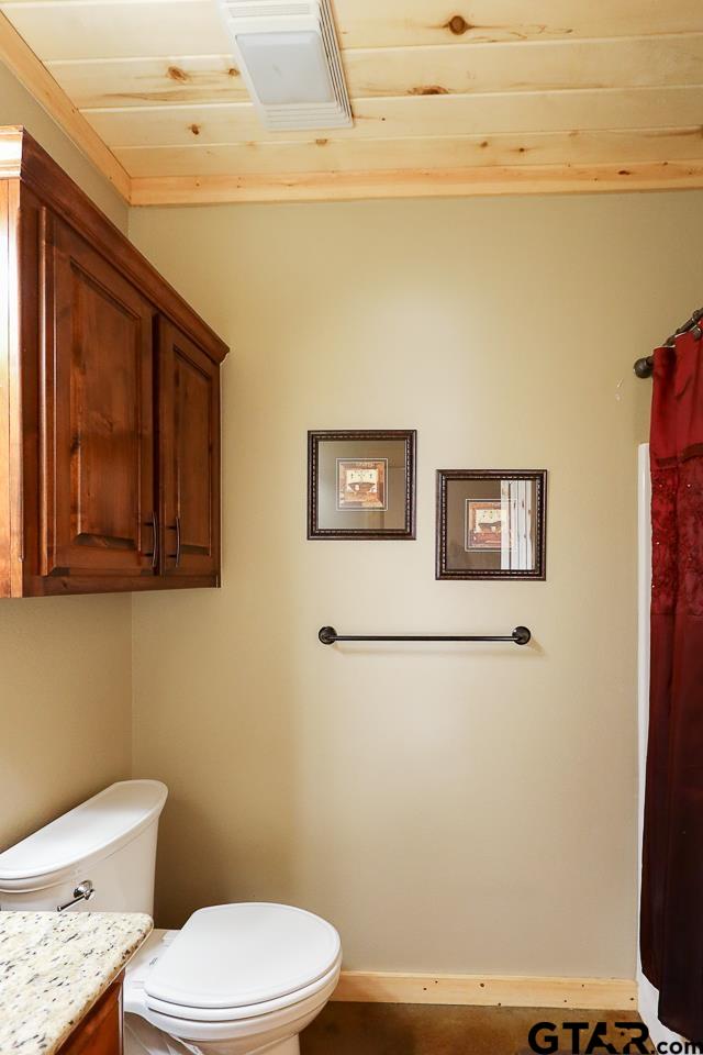4450 Southwest County Road 3010 Mount Vernon, TX 75457 - Photo 13 of 39 a white toilet sitting next to a shower curtain