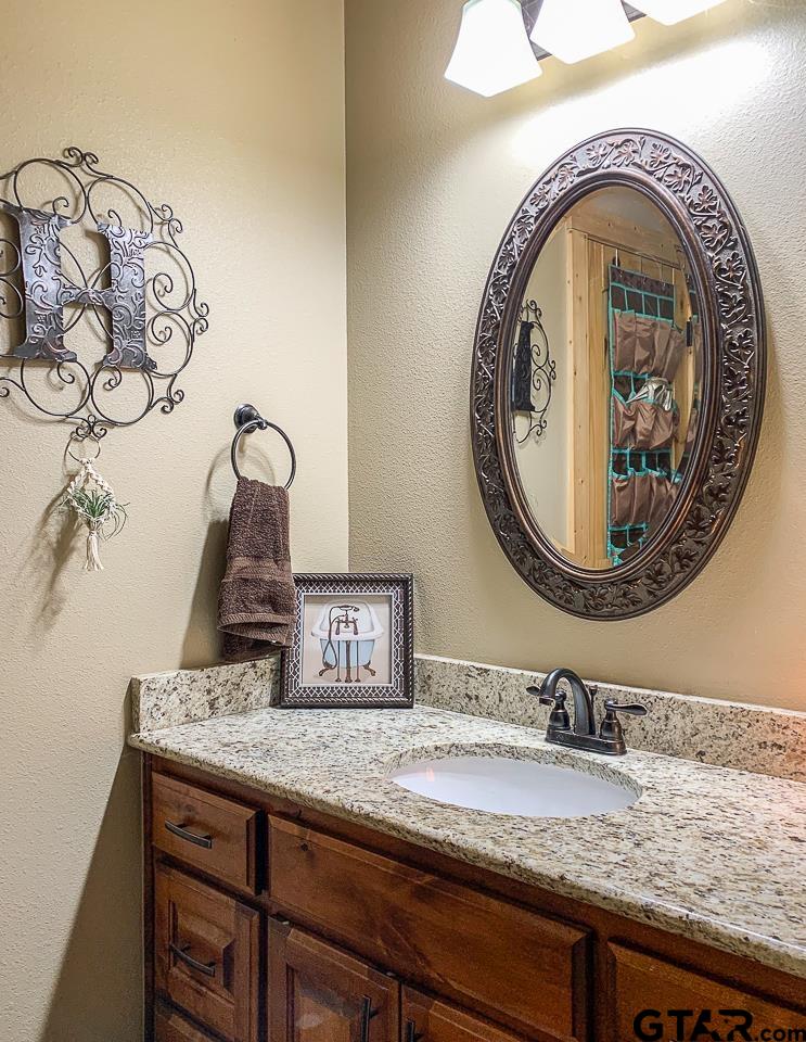 4450 Southwest County Road 3010 Mount Vernon, TX 75457 - Photo 15 of 39 a bathroom with a granite countertop sink and a mirror