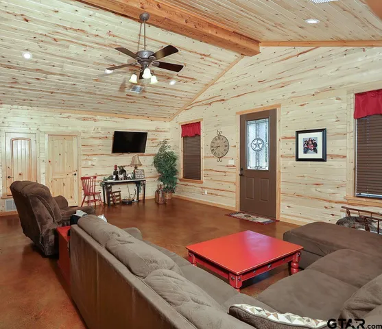 a living room with furniture a flat screen tv and kitchen view