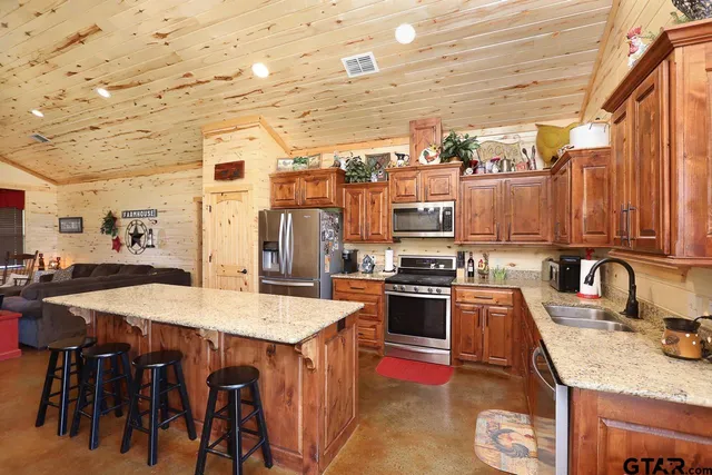 a kitchen with stainless steel appliances granite countertop a sink a stove and refrigerator