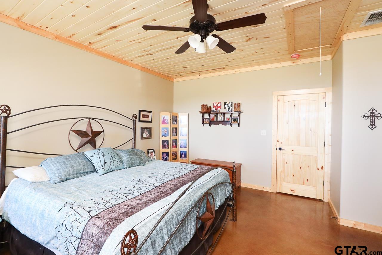 4450 Southwest County Road 3010 Mount Vernon, TX 75457 - Photo 10 of 39 a bedroom with a bed and a chandelier