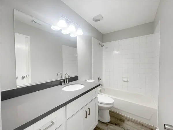 a bathroom with a granite countertop sink a toilet and a bathtub