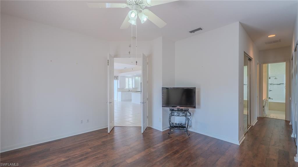 3766 Whidbey Way Naples, FL 34119 - Photo 17 of 50 Unfurnished living room featuring dark wood-type flooring and ceiling fan