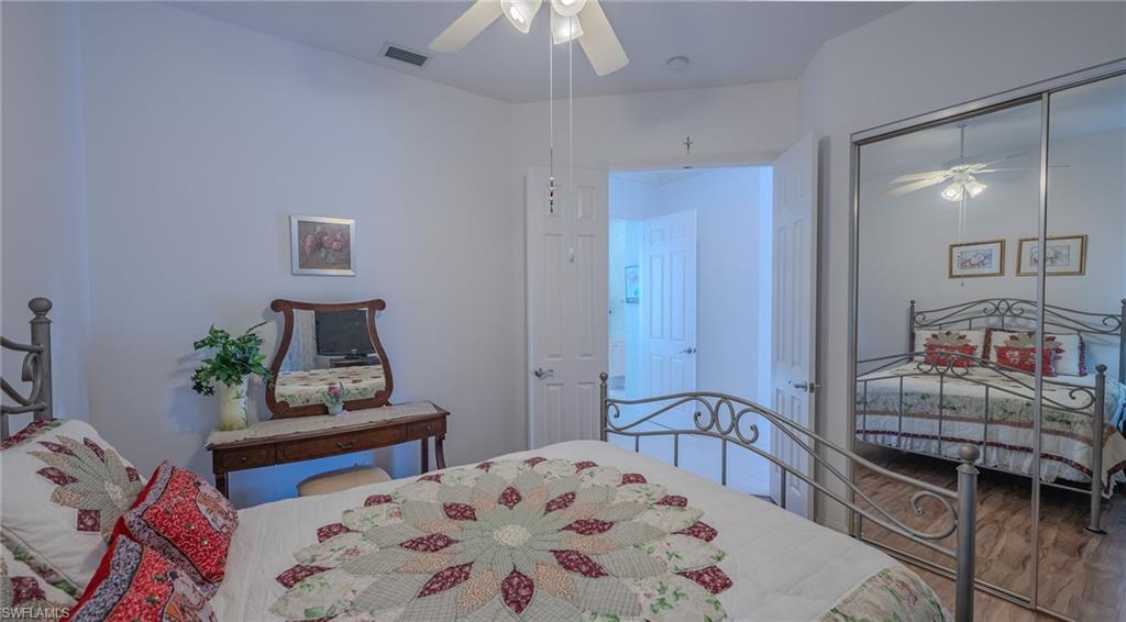 3766 Whidbey Way Naples, FL 34119 - Photo 30 of 50 Bedroom featuring a ceiling fan, a closet, and wood finished floors
