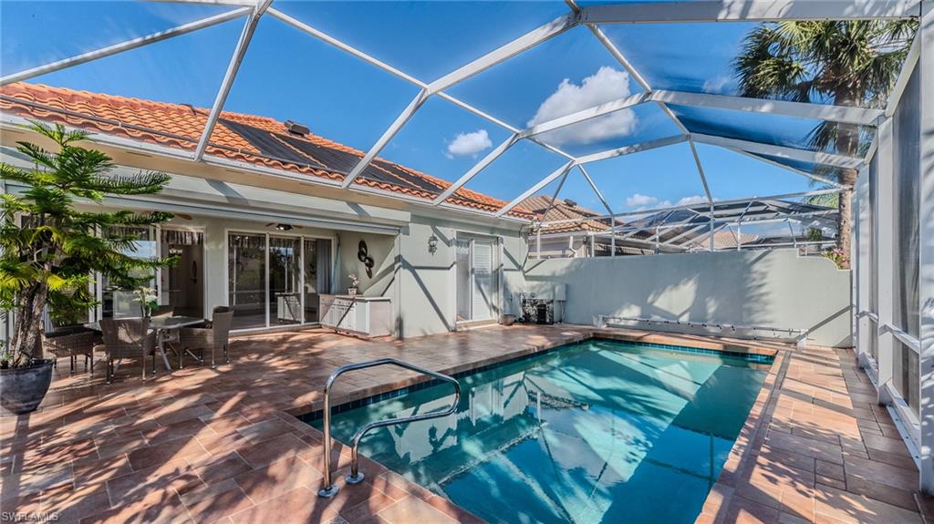 3766 Whidbey Way Naples, FL 34119 - Photo 37 of 50 View of swimming pool with a sunroom, glass enclosure, a patio, and outdoor dining area