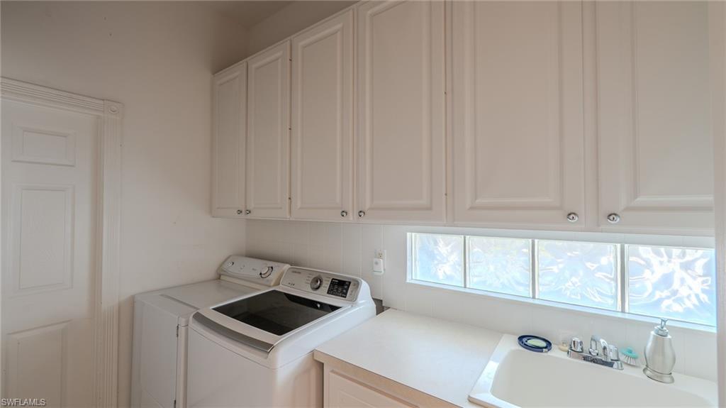 3766 Whidbey Way Naples, FL 34119 - Photo 40 of 50 Laundry area featuring washing machine and dryer and cabinet space