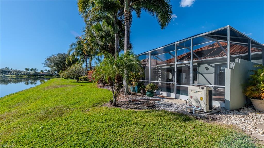 3766 Whidbey Way Naples, FL 34119 - Photo 42 of 50 Back of property featuring a sunroom, a lanai, a yard, and a water view