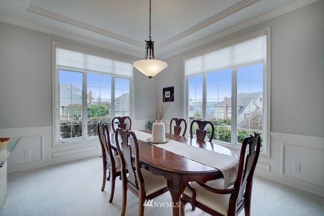 a kitchen with kitchen island a stove a refrigerator a dining table and chairs
