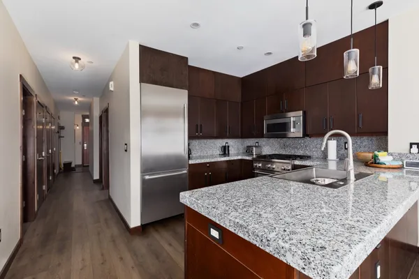 a kitchen with stainless steel appliances granite countertop a sink refrigerator and microwave