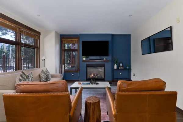 a living room with furniture a flat screen tv and a fireplace