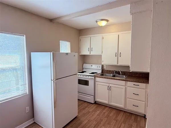 a kitchen with appliances a sink and cabinets