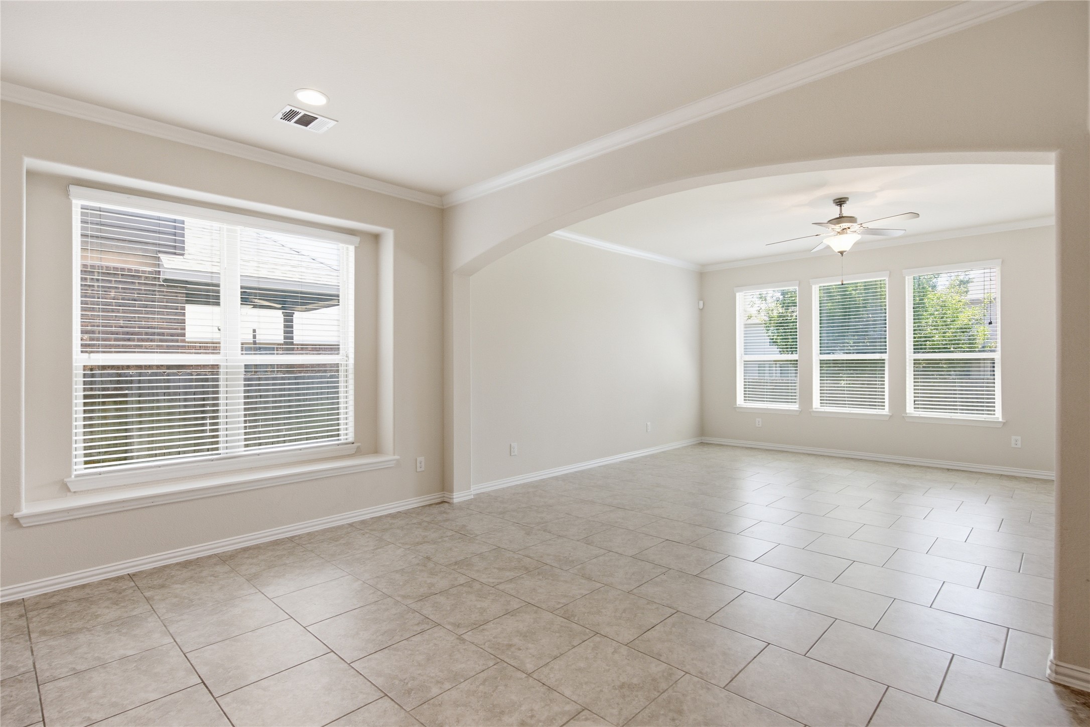 2601 Rough Berry Road Pflugerville, TX 78660 - Photo 14 of 36 Natural light floods this spacious living area, showcasing its tiled floors and elegant crown molding.