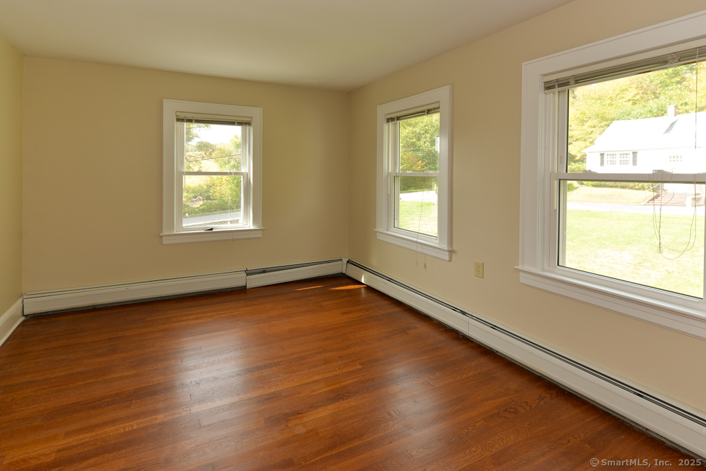 124 Purchase Brook Road Southbury, CT 06488 - Photo 14 of 26 a view of an empty room with wooden floor and a window