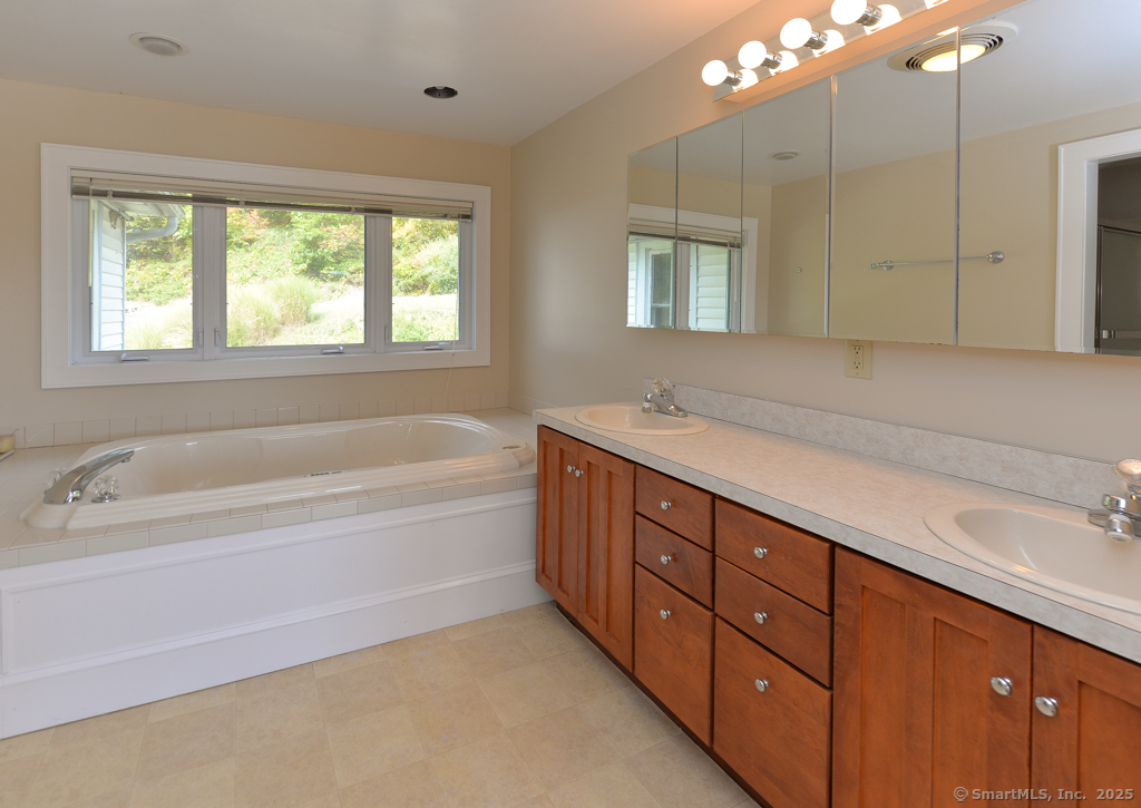124 Purchase Brook Road Southbury, CT 06488 - Photo 17 of 26 a spacious bathroom with a tub sink and mirror