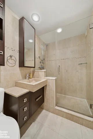 a bathroom with a sink a toilet and shower