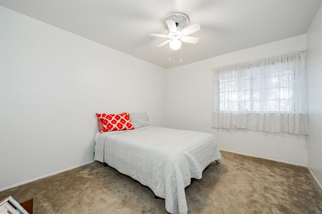 1759 Gross Road Dallas, TX 75228 - Photo 26 of 38 a bedroom with a bed and a chandelier