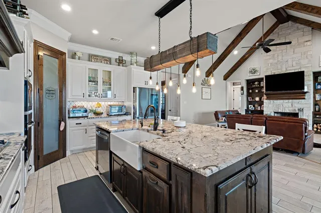 a kitchen with stainless steel appliances granite countertop a sink refrigerator stove and microwave