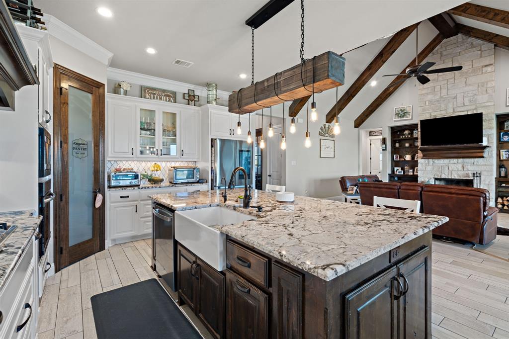 a kitchen with stainless steel appliances granite countertop a sink refrigerator stove and microwave