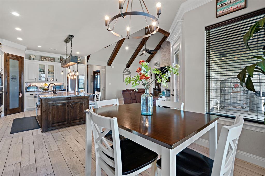 3032 Perkins Weatherford, TX 76088 - Photo 13 of 40 a kitchen with stainless steel appliances granite countertop a sink dishwasher and a dining table with wooden floor