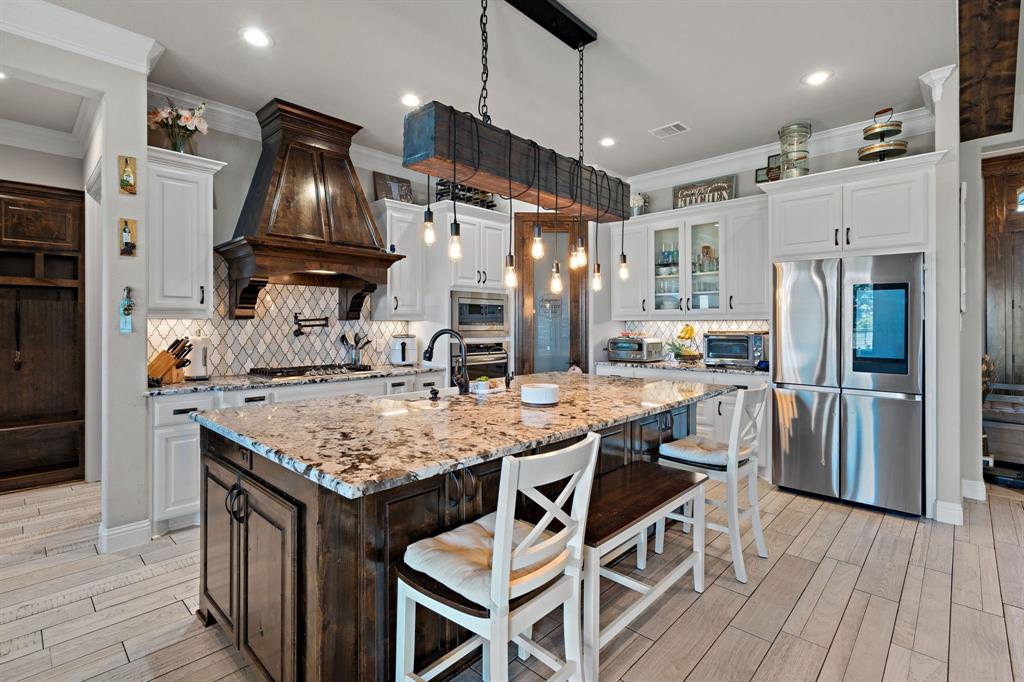 3032 Perkins Weatherford, TX 76088 - Photo 20 of 40 a kitchen with stainless steel appliances granite countertop a sink stove and refrigerator