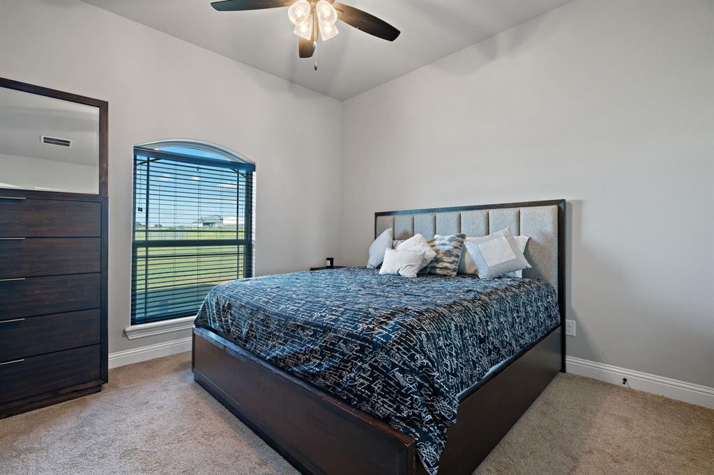 3032 Perkins Weatherford, TX 76088 - Photo 35 of 40 a bed sitting in a bedroom next to a window and a chandelier