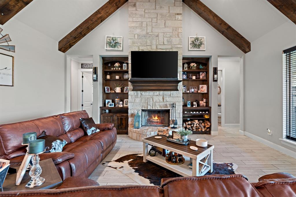 3032 Perkins Weatherford, TX 76088 - Photo 9 of 40 a living room with furniture a flat screen tv and a fireplace