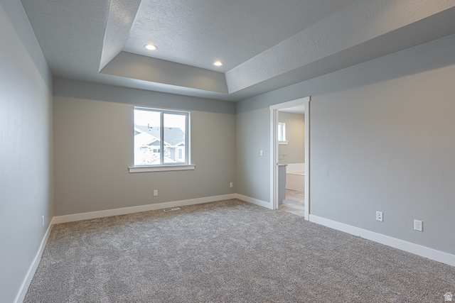 2257 South 1090 West, Unit 74 Nibley, UT 84321 - Photo 16 of 40 Room featuring a tray ceiling with recessed lighting, a window with white trim, gray walls, and gray carpeting