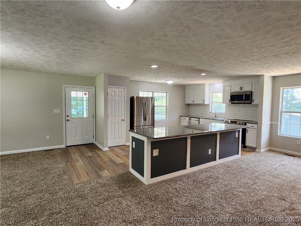 5444 Rockfish Road Raeford, NC 28376 - Photo 11 of 37 a large kitchen with stainless steel appliances granite countertop a stove and a sink