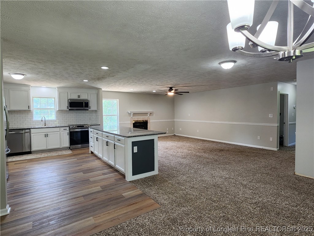 5444 Rockfish Road Raeford, NC 28376 - Photo 12 of 37 a large kitchen with stainless steel appliances a large counter top a stove and a refrigerator