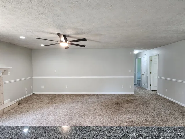 a view of a room with a empty space and a ceiling fan