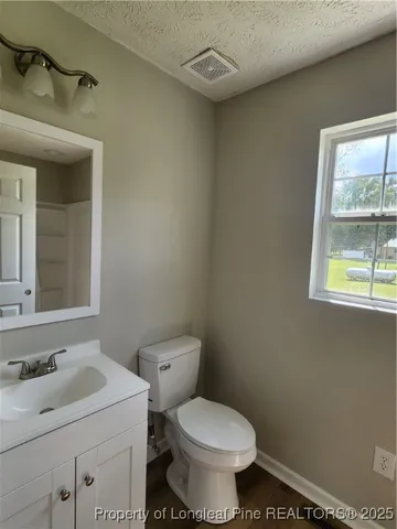 a bathroom with a sink toilet and window