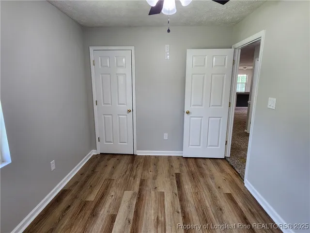 a view of a room with wooden floor staircase and a kitchen space
