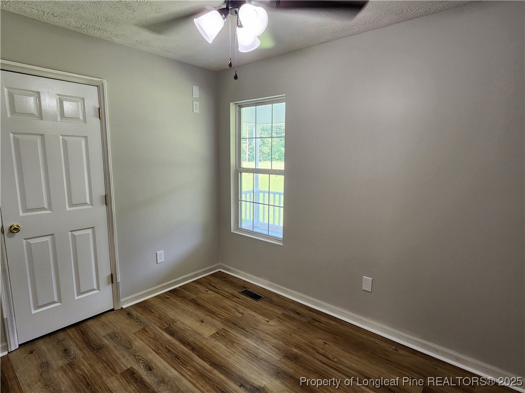 5444 Rockfish Road Raeford, NC 28376 - Photo 29 of 37 a view of empty room with wooden floor and fan