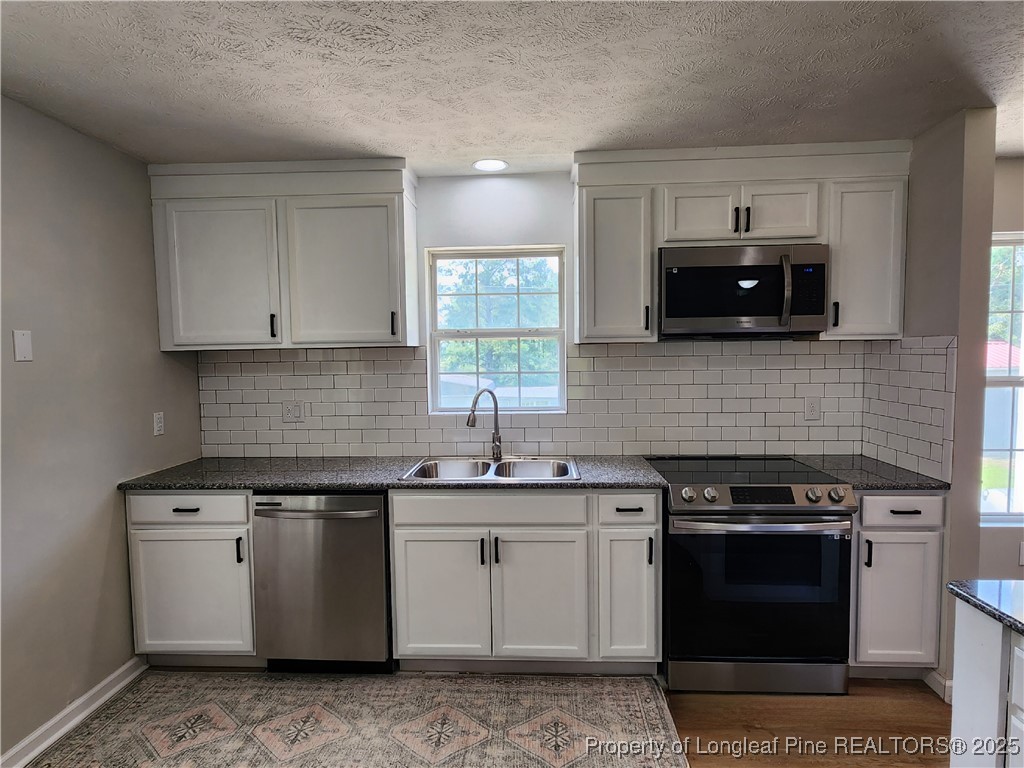 5444 Rockfish Road Raeford, NC 28376 - Photo 5 of 37 a kitchen with stainless steel appliances granite countertop a stove a sink and a microwave