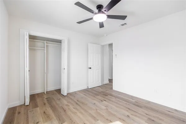 a view of a big room with wooden floor and a ceiling fan