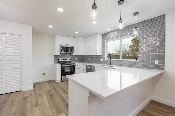 a large kitchen with granite countertop a large counter top stainless steel appliances and a window