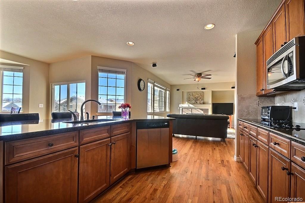 17874 West 77th Lane Arvada, CO 80007 - Photo 14 of 33 a kitchen with lots of counter top space and wooden floor