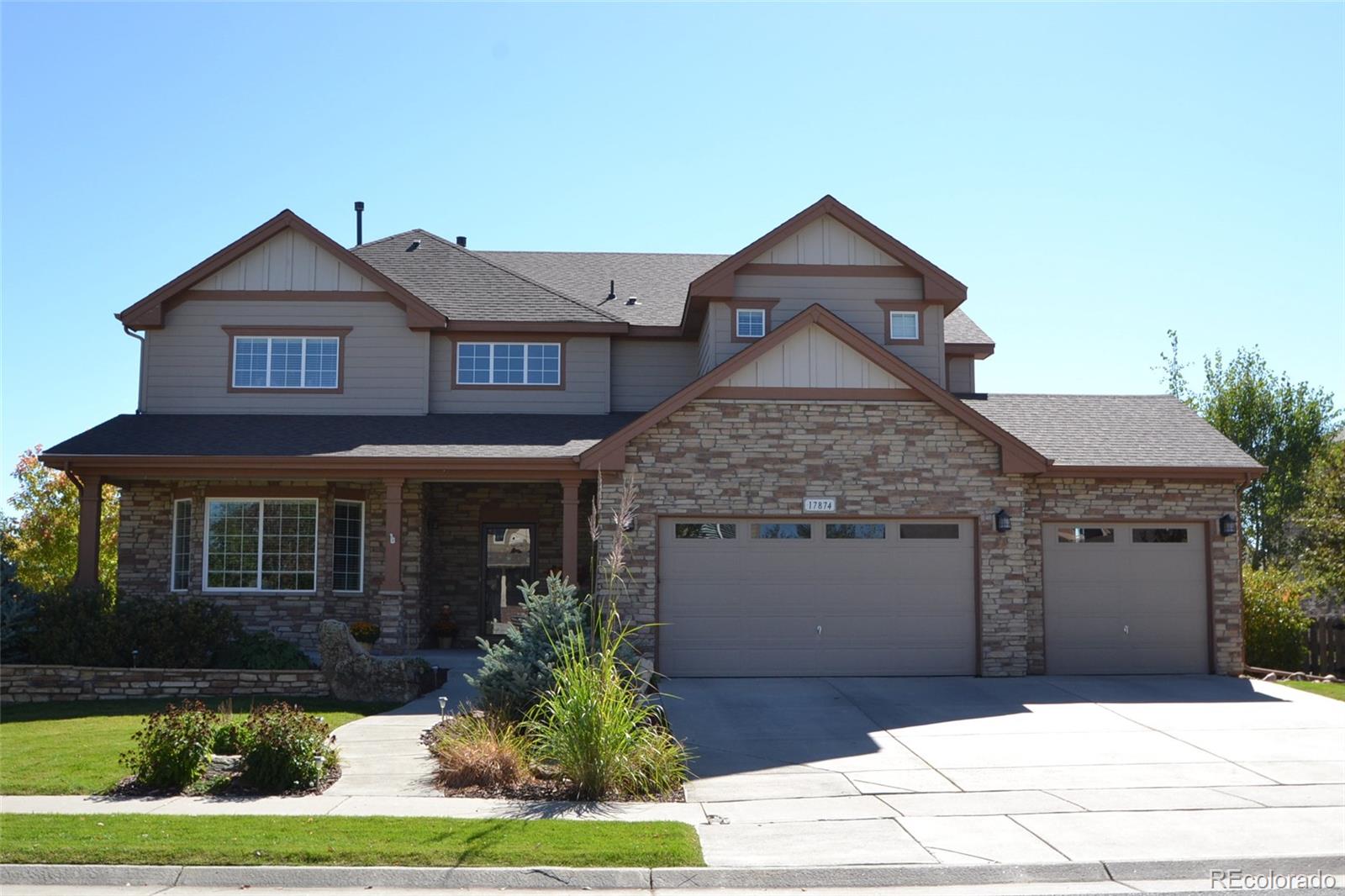 17874 West 77th Lane Arvada, CO 80007 - Photo 2 of 33 a front view of a house with a yard and garage