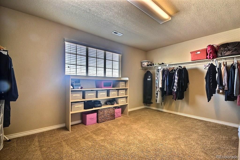 17874 West 77th Lane Arvada, CO 80007 - Photo 24 of 33 a view of walk in closet with clothes and shoes