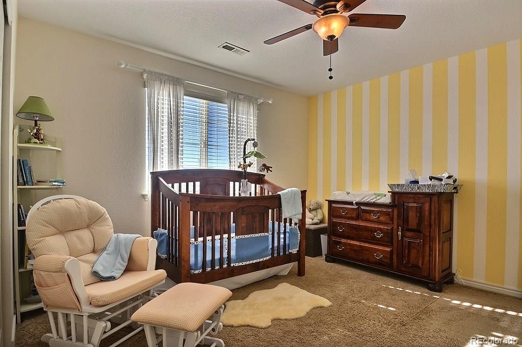 17874 West 77th Lane Arvada, CO 80007 - Photo 30 of 33 a bedroom with furniture and windows