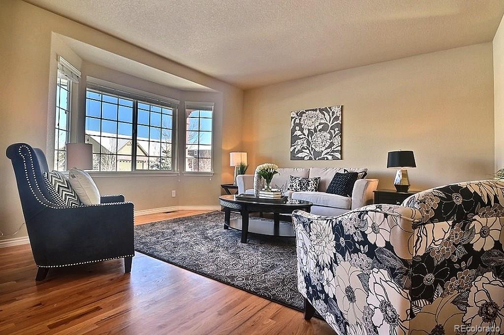 17874 West 77th Lane Arvada, CO 80007 - Photo 9 of 33 a living room with furniture and wooden floor