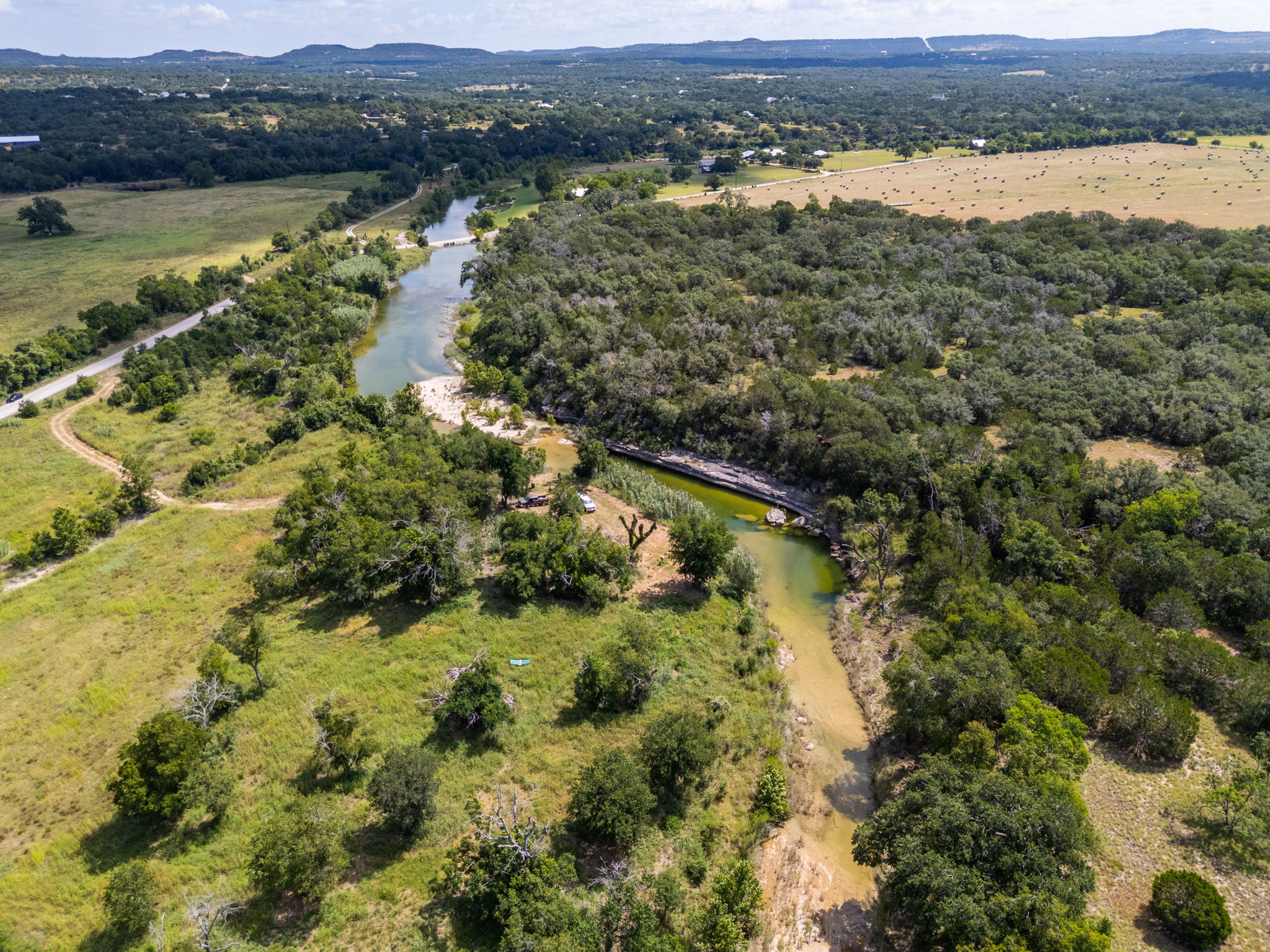 5385 Ranch Road 165 Blanco, TX 78606 - Photo 37 of 40 A winding river traverses a verdant landscape, showcasing the natural beauty of the property.