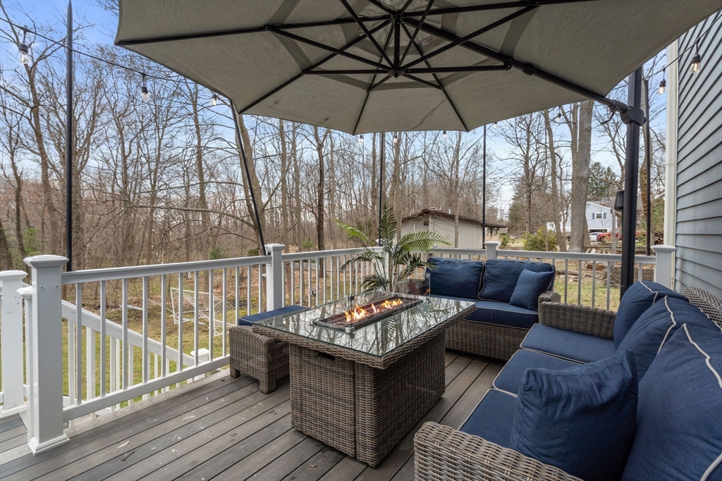 518 Maple Street Danvers, MA 01923 - Photo 16 of 20 a view of balcony with furniture and umbrella