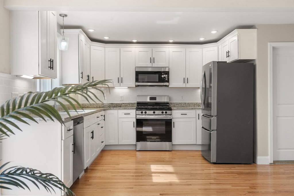 518 Maple Street Danvers, MA 01923 - Photo 5 of 20 a kitchen with granite countertop a refrigerator and a stove top oven
