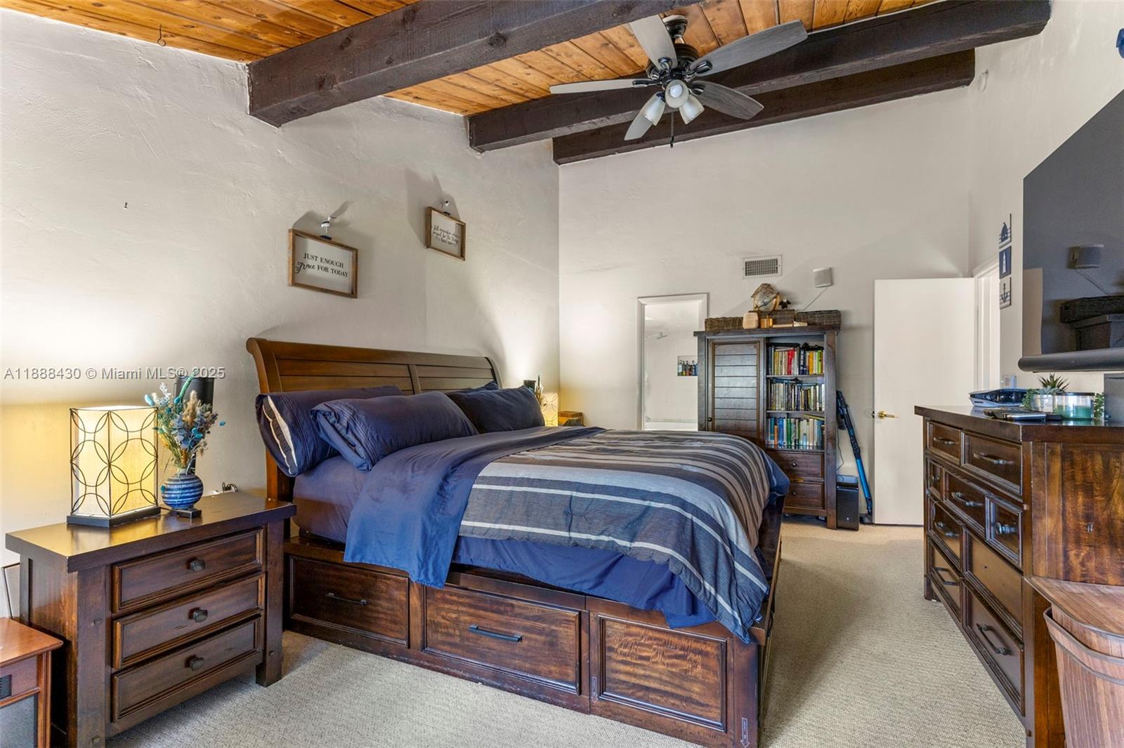 19440 Northeast 26th Avenue, Unit 53B Miami, FL 33180 - Photo 16 of 33 a bedroom with a bed and a flat tv screen on the dresser