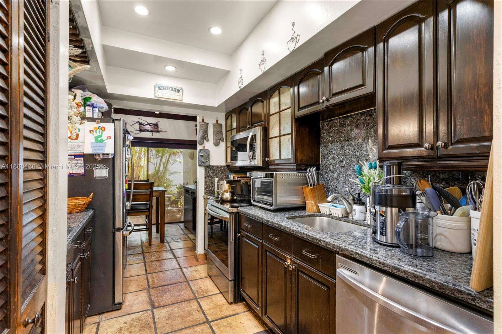 19440 Northeast 26th Avenue, Unit 53B Miami, FL 33180 - Photo 17 of 33 a kitchen with stainless steel appliances granite countertop lots of counter top space